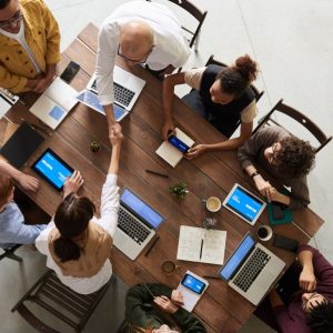 OneUP, people around a desk collaborating